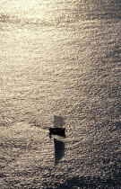 Un petit canot à misaine dans une mer d'huile au soleil couchant, © Guillaume Plisson / Plisson La Trinité / AA00042 - Nos reportages photos - Vertical