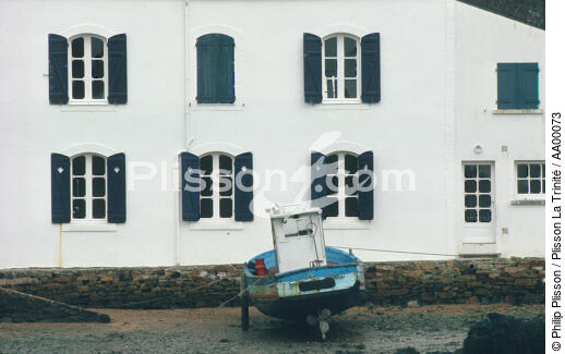 Un canot à moteur béquiller devant la maison aux volets bleus de Mane Verh. - © Philip Plisson / Plisson La Trinité / AA00073 - Nos reportages photos - Site [56]