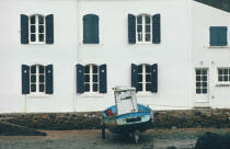 Un canot à moteur béquiller devant la maison aux volets bleus de Mane Verh. © Philip Plisson / Plisson La Trinité / AA00073 - Nos reportages photos - Rivière [56]
