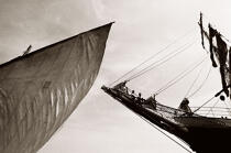 Le beaupré du Belem, suspendu entre ciel et mer, regarde passer le canot à misaine du bord. © Philip Plisson / Plisson La Trinité / AA04484 - Nos reportages photos - Trois-mâts barque